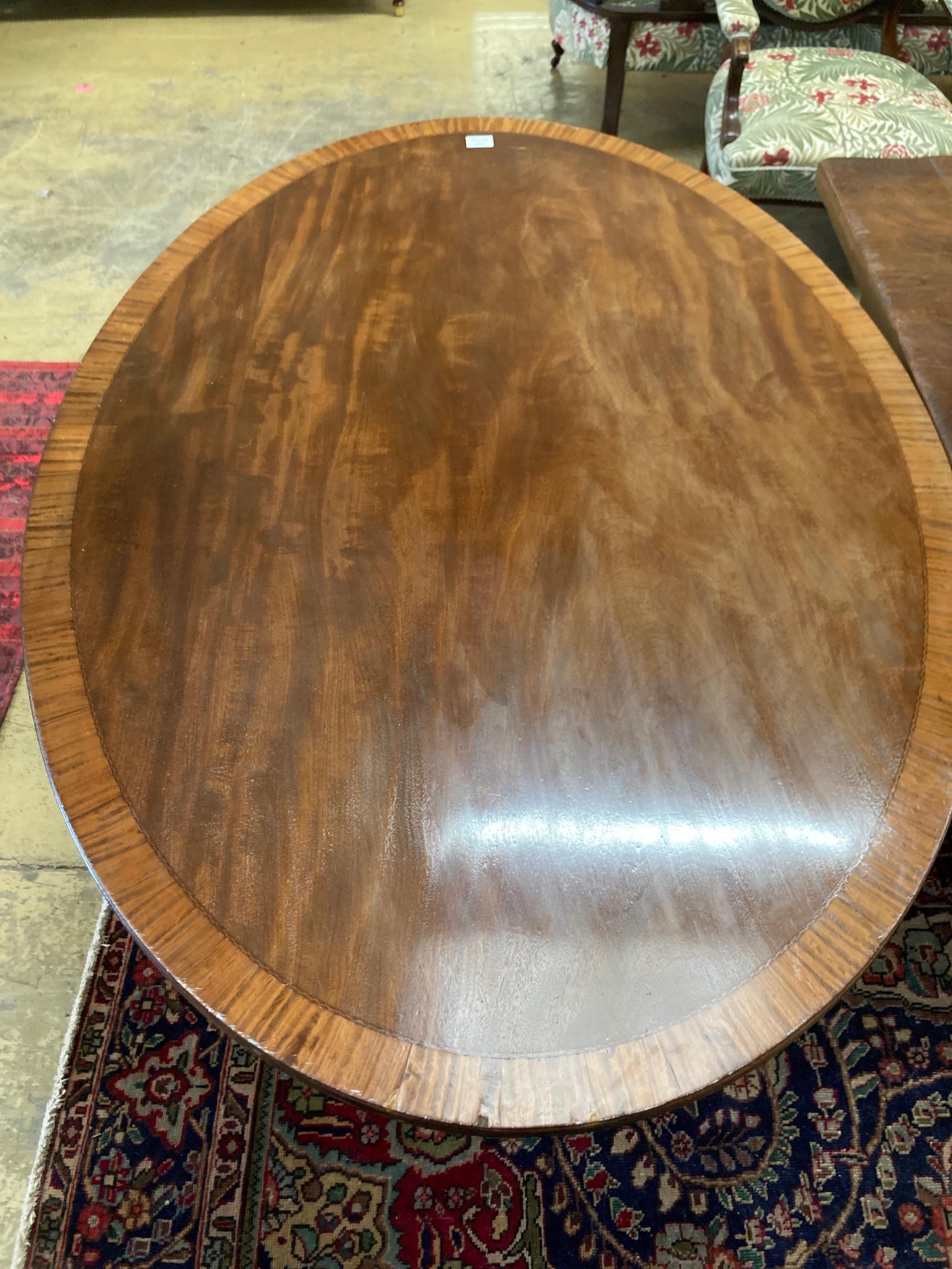 A Regency style oval banded mahogany dining table, length 150cm, depth 103cm, height 76cm